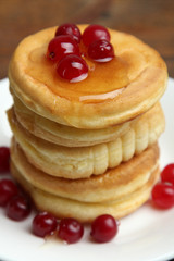 Stack of pancakes with berries on a plate.