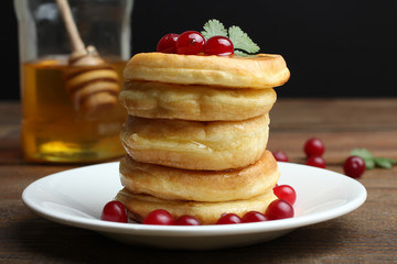 Pancakes with berries, honey in the plate.