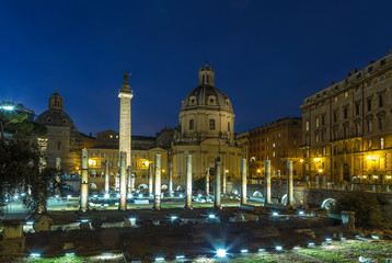 Fototapeta premium Rome, Italy. Emperor Trajan's Forum Ruins, 100 - 112 years AD. Trajan's Column (113) and the Church of the Holy Name of Mary (1736 - 1738). Night lights. Blue sky