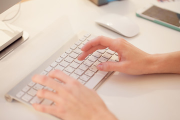 Closeup of a female hands typing on laptop keyboard in the office