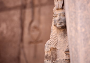 Ancient Egyptian goddess Isis and Ankh the ancient symbol of life, carved into an ancient temple wall in the background. Karnak, Luxor, Egypt - obrazy, fototapety, plakaty