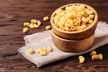 Fototapeta na wymiar Elbow macaroni in a wooden bowl