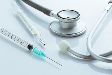 Medical equipment : stethoscope, thermometer, syringe on white b