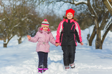 joyful children playing in snow. Two happy girls having fun outside winter day