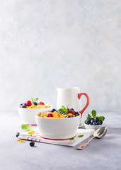 Obraz na płótnie Canvas Healthy breakfast with corn flakes, berries and milk on light gray background. Copy space.