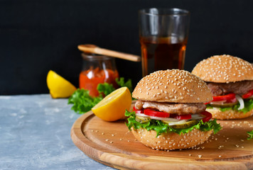 Big homemade burger with meat, tomato and sauce.