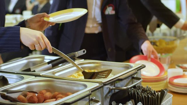 pupils take plates and put food into them in school canteen