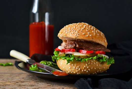 Homemade burger with beef, salad and tomato sauce.