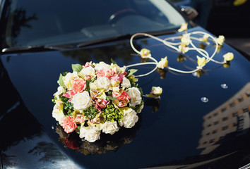 Bouquet of colorful flowers on the black wedding car