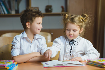 Children learning and doing homework in school classroom