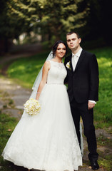 Naklejka premium Newlyweds together in the beautiful park in the wedding day