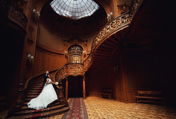 Embracement of the newlyweds on the stairs in the palace