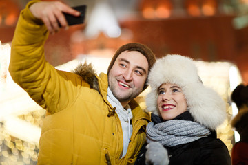 Couple photographing themselves on street