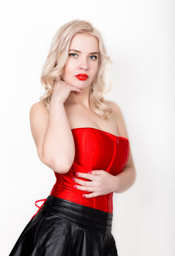 beautiful sexy blonde woman with large breasts in a red corset and short black skirt