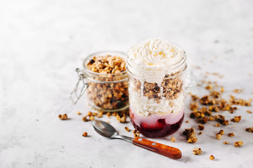 Healthy breakfast with granola, jam  and cream in a glass jar
