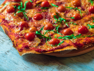 Rustic pizza with mozzarella, basil and cherry tomatoes.