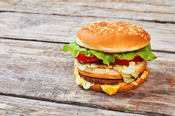 Hamburger on light wooden surface.