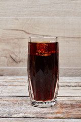 Cola drink on wooden background.