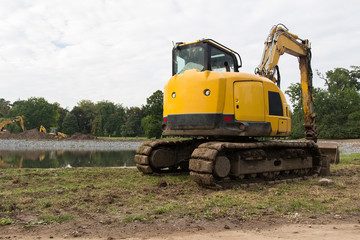 Fototapeta na wymiar Heavy construction equipment. Yellow excavator on the construction site