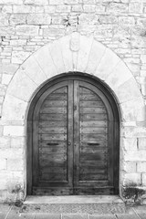 The entrance wooden door in an old Italian house (black and white).