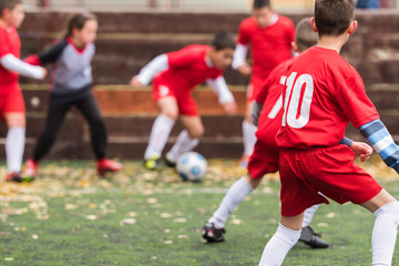 Fototapeta premium Boys kicking soccer ball at sports field