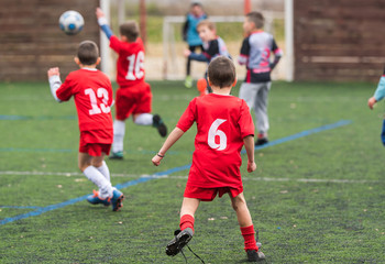  Boys kicking soccer ball at sports field