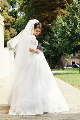 Look from behind at bride fixing her dress