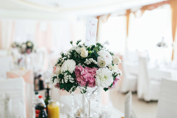 Bouquet of pink and white paper flowers stand on dinner table