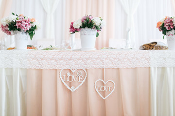 Decorative hearts with letterings 'Love' inside hang from dinner table