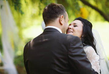 Happy bride in the embracement of her groom