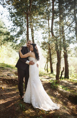 Romantic embracement of the newlyweds  in the wood