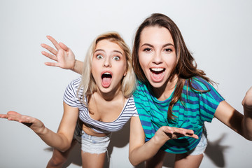Portrait of two cheerful young female teens having fun together