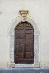 Fototapeta na wymiar The entrance wooden door in an old Italian house. Isolated on white background. Clipping path included.