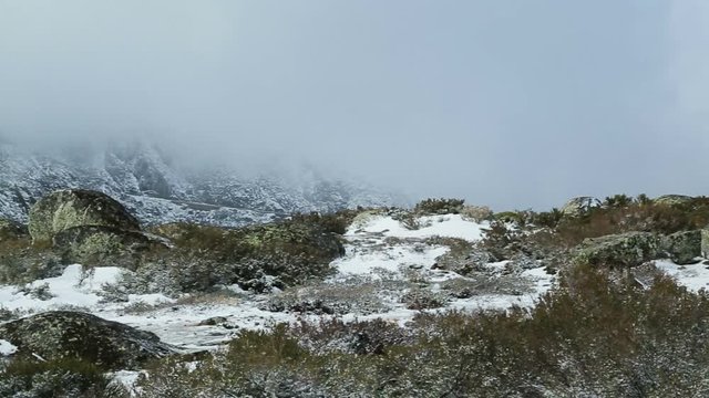 A telephoto panning shot of a wintry landscape in Serra da Estrela, Covilha, Portugal
