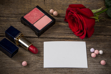 Obraz na płótnie Canvas Empty white paper for text, red lipstick, rouge, rose flower and