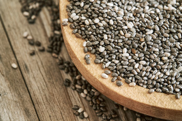 Chia seeds in wooden bowl on rustic background. Copy space