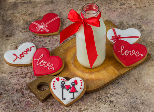 Valentine cookies and milk in a bottle on a wooden background