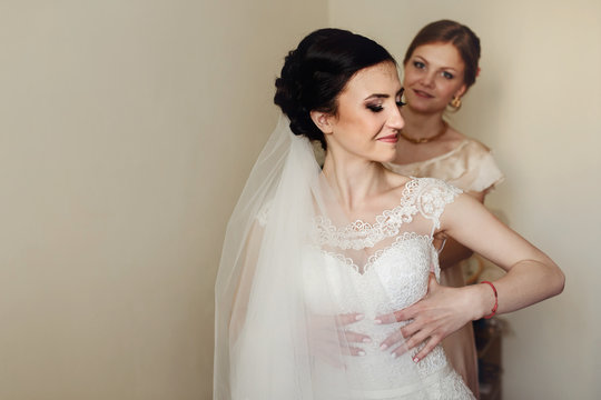 Charming bridesmaid looks from behind bride's shoulder