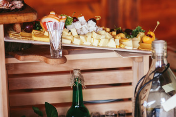 Pieces of cheese lie on the wooden dish