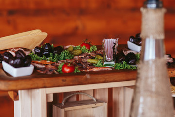 Pickled vegetables and salted meat lie on the wooden dish