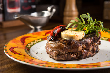 Grilled beef steak with cheese and pepper sauce on plate