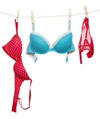 Female red panties and blue bra hanging on rope