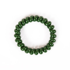 Round green spiral elastic band for hair is isolated on a white background