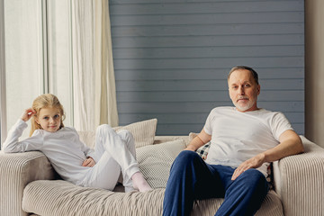 Cute granddaughter and grandparent resting at home together