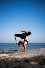 Fototapeta na wymiar Asian woman practice Yoga on the beach blue sky