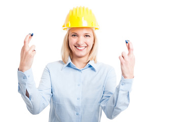 Female engineer wearing helmet showing double fingers crossed