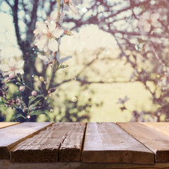 wooden rustic table in front of spring cherry tree
