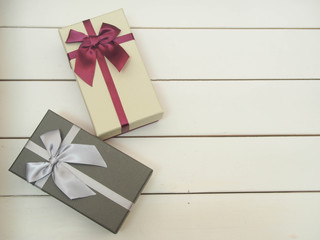 Gift boxes tied with ribbons on a white wooden table.