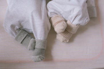 Obraz na płótnie Canvas legs of two babies in her pajamas and socks