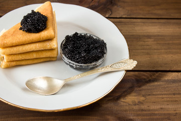 traditional russian Pancakes on plate with black caviar